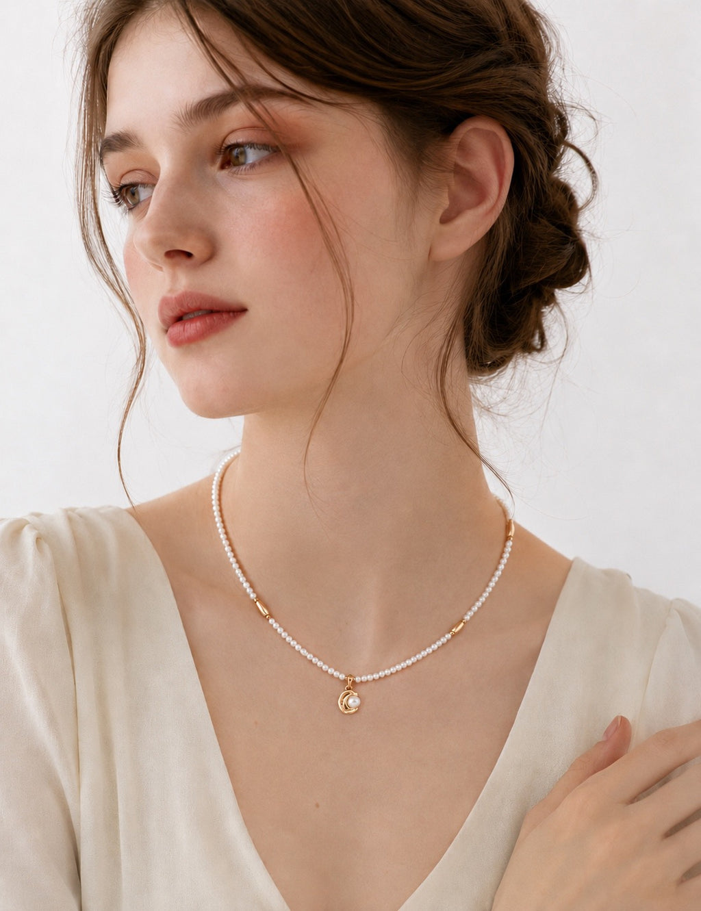 Vintage Pearl necklace worn with a cream V-neck blouse, showing small pearls and a vintage gold curved pendant