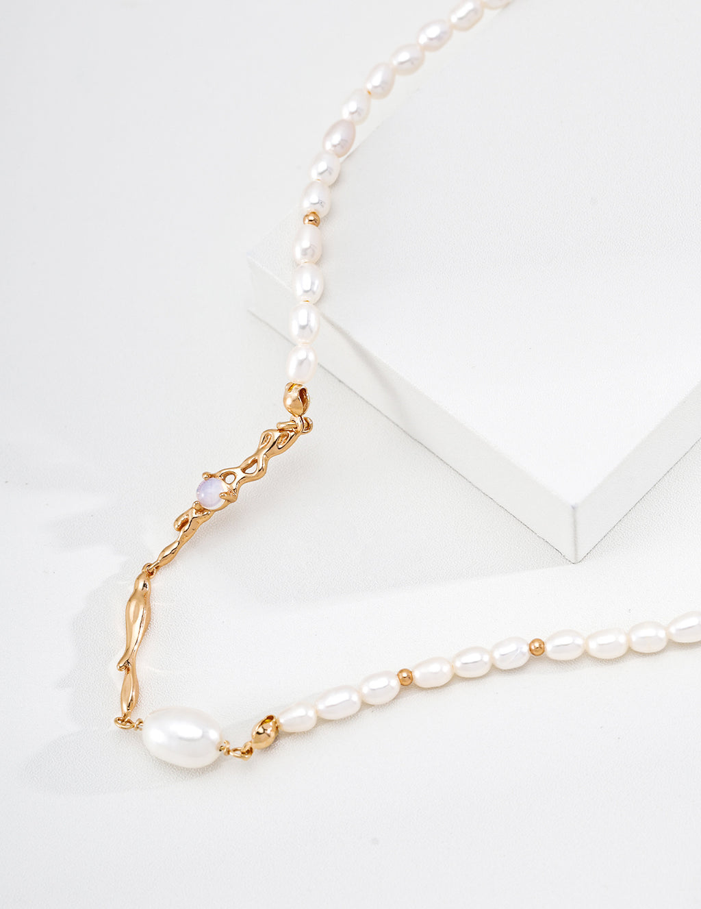 Close view of the vintage gold Liquid Metal pearl necklace, showing sculpted links and pearl accents on a white display