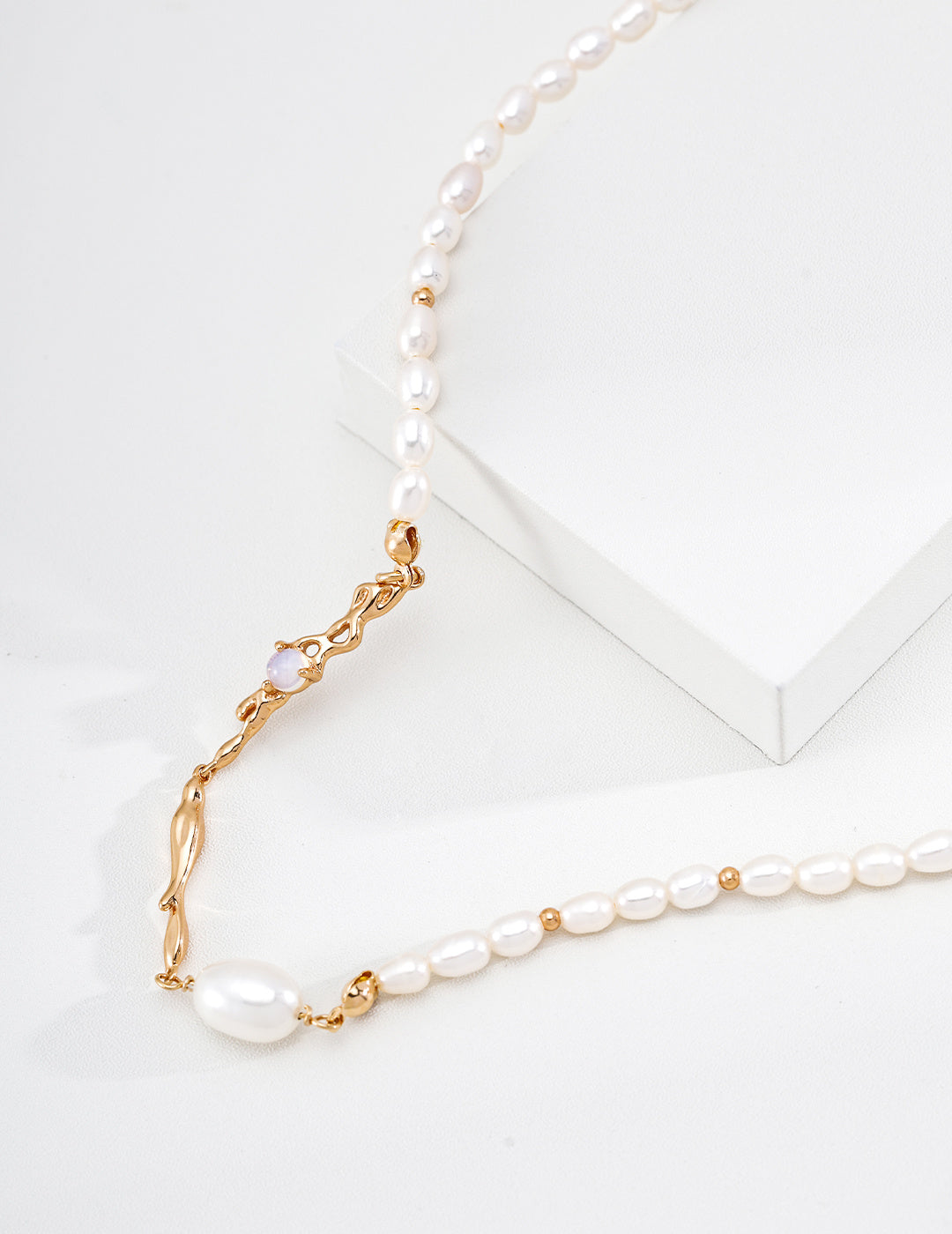 Close view of the vintage gold Liquid Metal pearl necklace, showing sculpted links and pearl accents on a white display