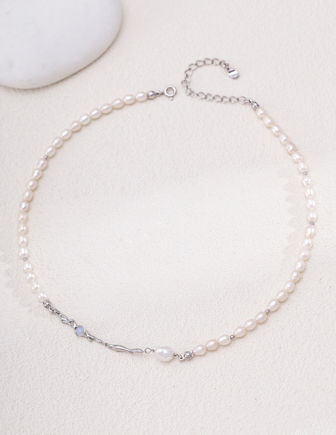 Liquid Metal pearl necklace in platinum silver arranged in a circle with sculpted accents and an extension chain