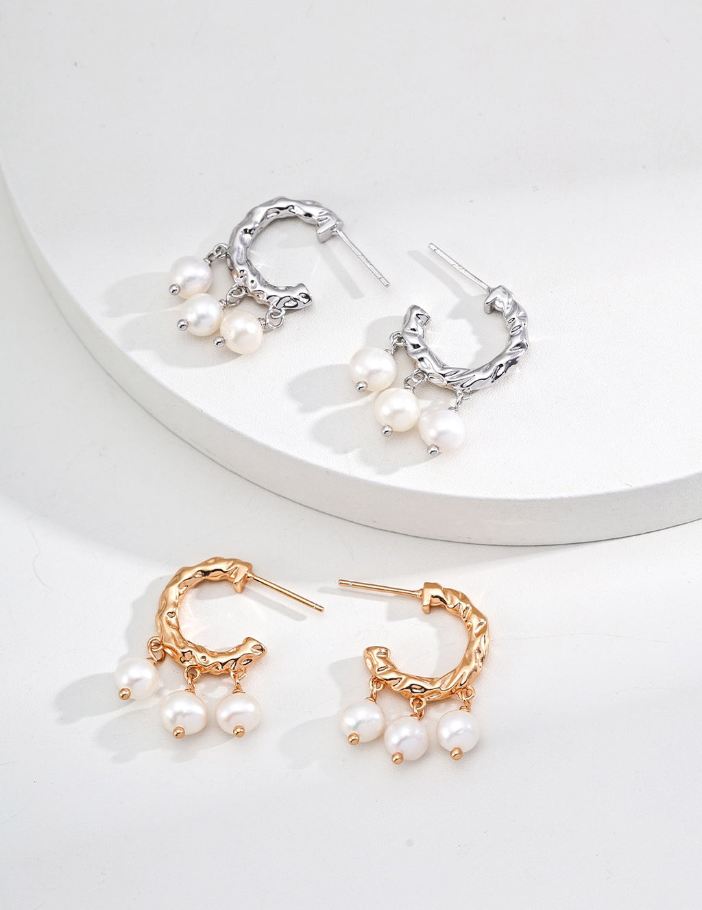 Textured pearl hoop earrings in platinum silver and vintage gold displayed together, each hoop with three pearl drops