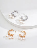 Textured pearl hoop earrings in platinum silver and vintage gold displayed together, each hoop with three pearl drops