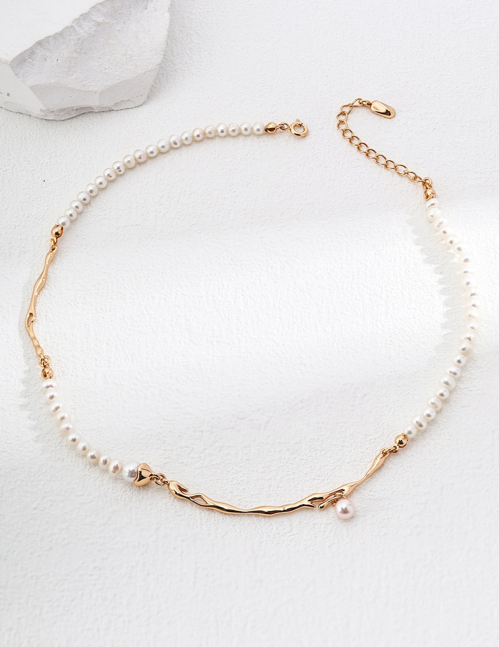 Geometric Baroque pearl necklace in vintage gold arranged in a circle, with irregular metal accents and a small pearl drop