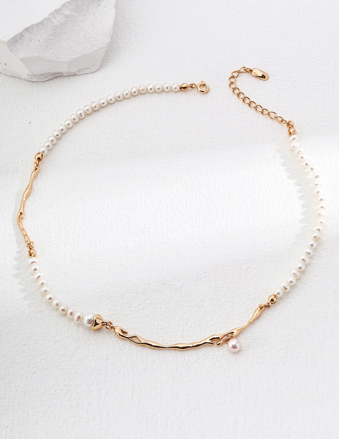 Geometric Baroque pearl necklace in vintage gold arranged in a circle, with irregular metal accents and a small pearl drop