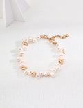 Baroque pearl bracelet in vintage gold arranged on a white surface, with irregular pearls and rounded gold accents
