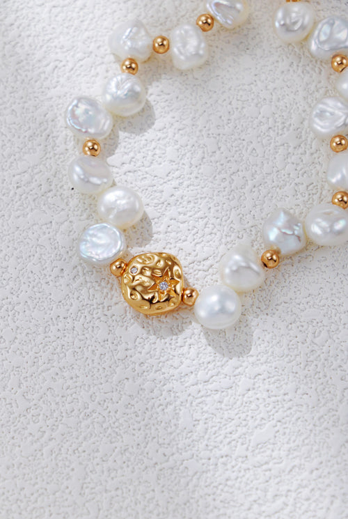 Close view of the Celestial Charm pearl bracelet in vintage gold, showing the textured round centerpiece and irregular pearls