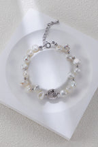 Celestial Charm pearl bracelet in platinum silver on a white display, with round spacers and a textured centerpiece